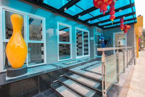 a blue building with a large orange vase on it at B-your home Hotel Don Mueang Airport Bangkok 如你家酒店 in Bangkok