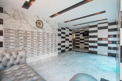 a swimming pool in a room with checkered walls at B-your home Hotel Don Mueang Airport Bangkok 如你家酒店 in Bangkok