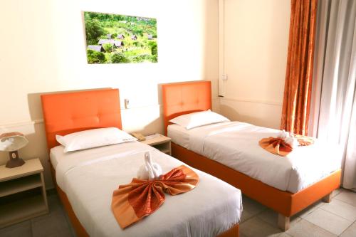 two beds in a room with bows on them at Hotel Mansel in Yaoundé