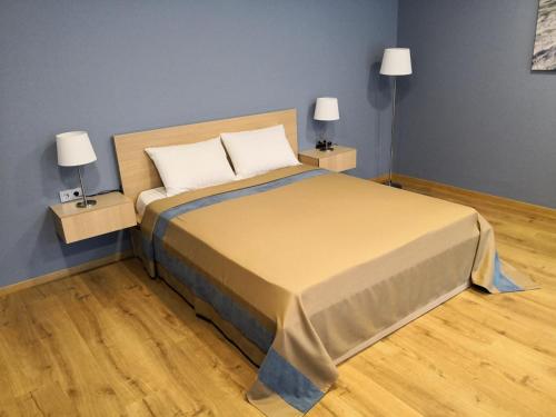 a bedroom with a large bed with two lamps at Žvėrinčiaus vila in Birštonas