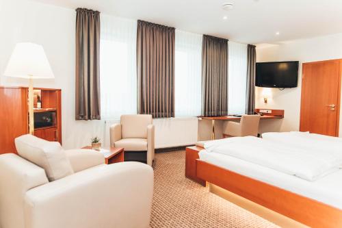 a hotel room with two beds and a television at Ringhotel Teutoburger Wald in Tecklenburg