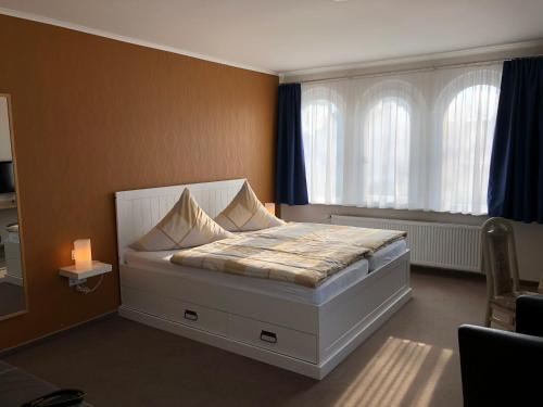 a bedroom with a white bed with a window at Das HOTELchen in Lübeck