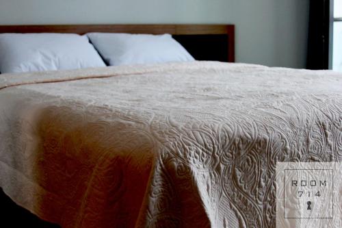 a bed with a white comforter with a sign on it at ORBI Palace Deluxe in Bakuriani