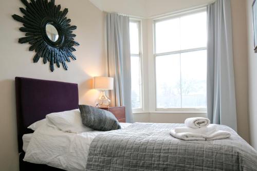 a bedroom with a bed with a mirror on the wall at Eildonside in Melrose