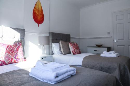 2 camas en una habitación con toallas en las camas en Meadowburn View, en Wishaw
