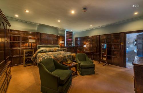 a bedroom with a bed and two chairs at The George Hotel of Stamford in Stamford