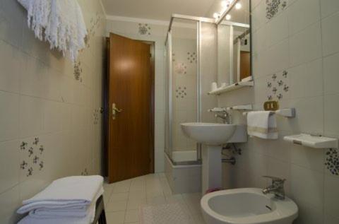 ガッリオにあるHotel Concordiaのバスルーム(洗面台、トイレ、鏡付)