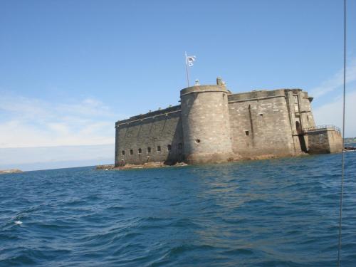 a castle on an island in the water at Ti Bihan - Meublé in Santec