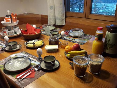 a wooden table with food and utensils on it at Bühl 3 in Affoltern