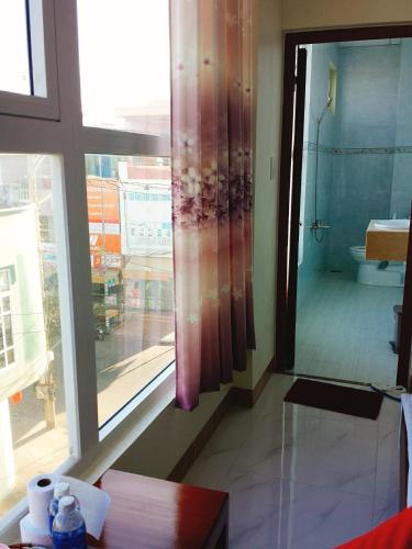 a bathroom with a large window and a view of a bathroom at Hotel Tan Phu in La Gi
