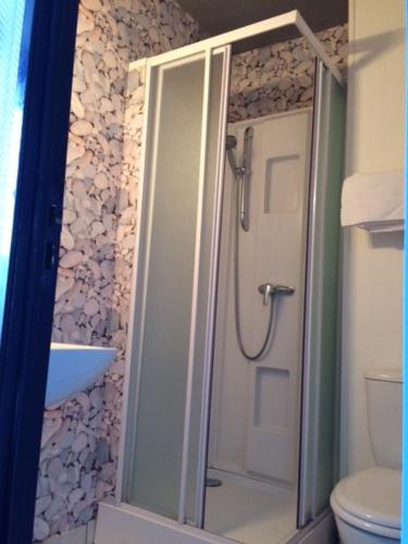 een badkamer met een douche en een toilet bij Hôtel de la Gare in Saint-Malo