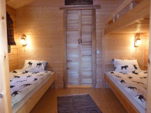 a room with two beds in a log cabin at Aha Lodge in Sorsele