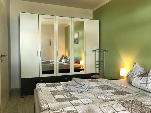 sypialnia z dużym łóżkiem i lustrem w obiekcie Ferienwohnungen am Hafen w mieście Stahlbrode