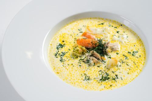 a bowl of soup on a white table at Hotel Alkor in Truskavets