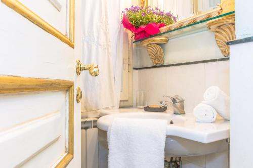 a bathroom with a sink and a toilet and a window at Italian Experience-Suite Medici in Florence
