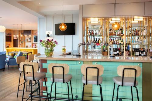 a bar in a restaurant with stools at Leonardo Hotel Liverpool in Liverpool