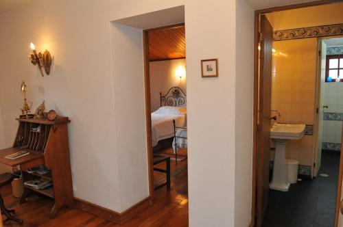 1 dormitorio con 1 cama y baño con lavabo. en Casa do Silvério en Santa Cruz do Douro