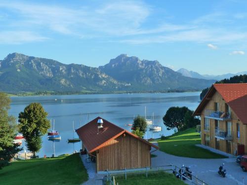a view of a lake with mountains in the background at Seehotel und Appartements Schnöller in Rieden am Forggensee