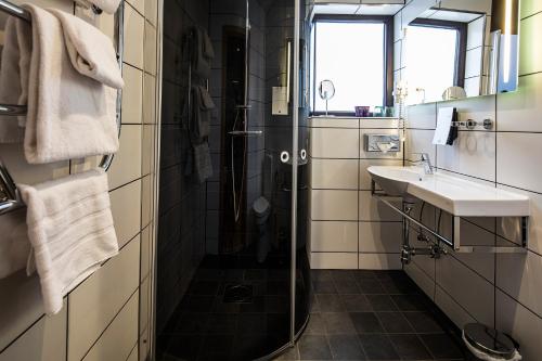 a bathroom with a shower and a sink at Clarion Collection Hotel Bristol in Arvika