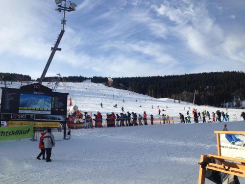 un groupe de personnes sur une piste de ski dans la neige dans l'établissement Fewo Bergblick, à Kurort Oberwiesenthal