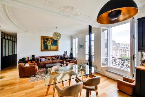 un salon avec une table en verre et des chaises dans l'établissement Hôtel de ville, à Levallois-Perret