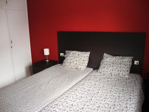 a bedroom with a bed and a red wall at Apartamentos Arinsal 3000 in Arinsal