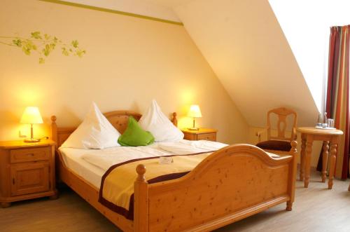 a bedroom with a wooden bed with green pillows at Hotel Speeter in Weisenheim am Berg