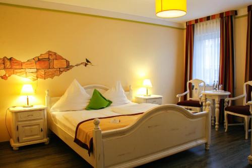 a bedroom with a bed and two tables and chairs at Hotel Speeter in Weisenheim am Berg
