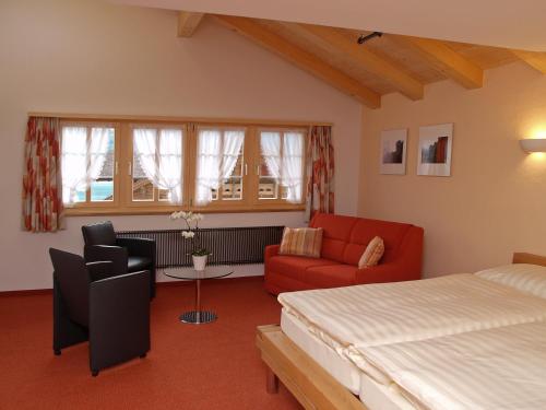 um quarto com uma cama, um sofá e uma mesa em Hotel Steinbock em Brienz