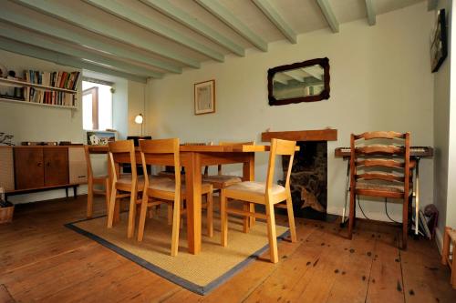 a dining room with a wooden table and chairs at Bryn Tirion in Morfa Nefyn