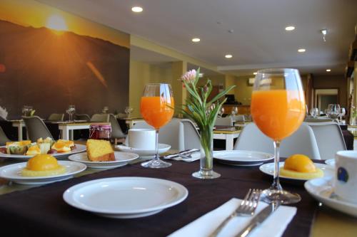 a table with two glasses of orange juice on it at Beleza Serra Guide Hotel in Geres