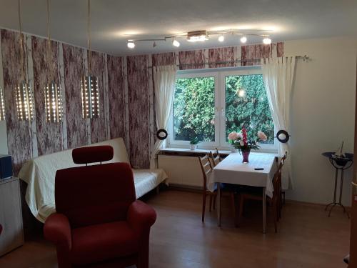 Un dormitorio con una cama y una mesa y una ventana. en Haus Edzards, en Neuharlingersiel