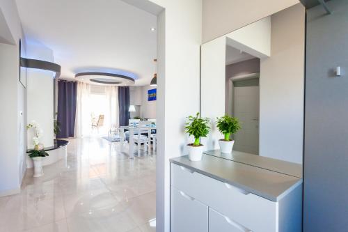 a kitchen with white cabinets and potted plants at Gold & Silver Apartments in Brna