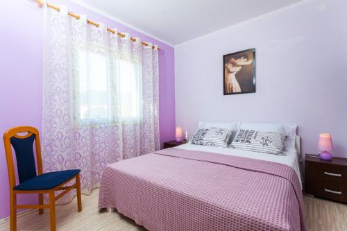 a purple bedroom with a bed and a blue chair at Gold & Silver Apartments in Brna