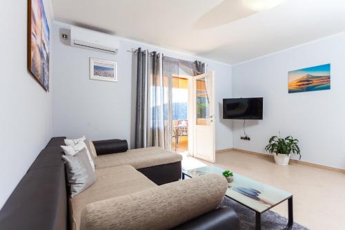 a living room with a couch and a table at Gold & Silver Apartments in Brna