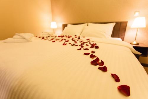 a bunch of rose petals on a bed at Garni Hotel President de Luxe in Kragujevac