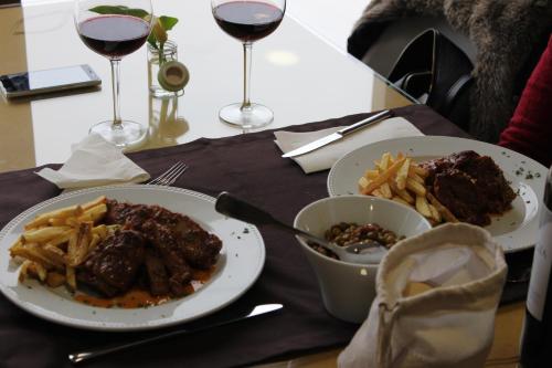 a table with two plates of food and glasses of wine at Beleza Serra Guide Hotel in Geres