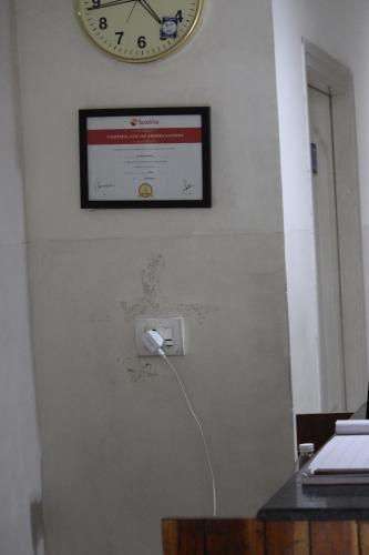 a clock hanging on a wall with a socket at Deccan Comforts in Hyderabad