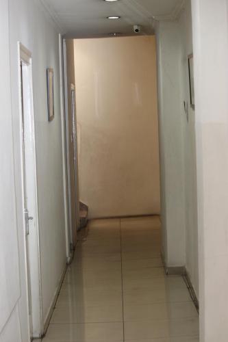 an empty hallway with a door and a tile floor at Deccan Comforts in Hyderabad