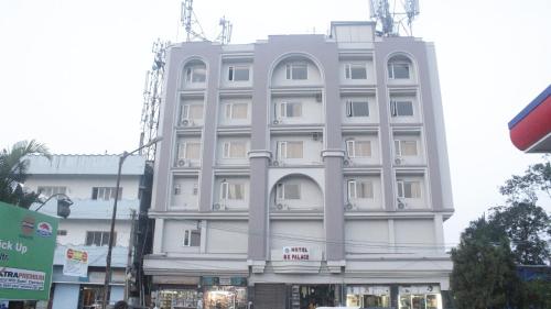 ein großes weißes Gebäude an einer Stadtstraße in der Unterkunft GK PALACE Pure VEG Hotel in Jorhat