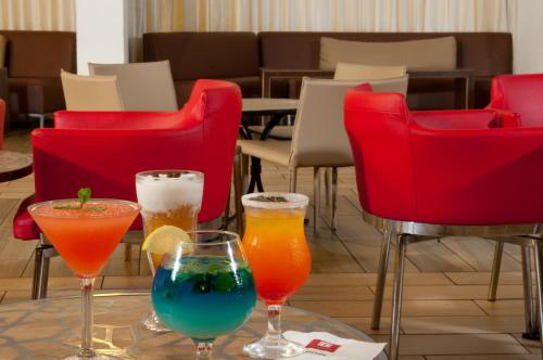a table with four drinks on a table with red chairs at Leonardo Club Tiberias - All Inclusive in Tiberias