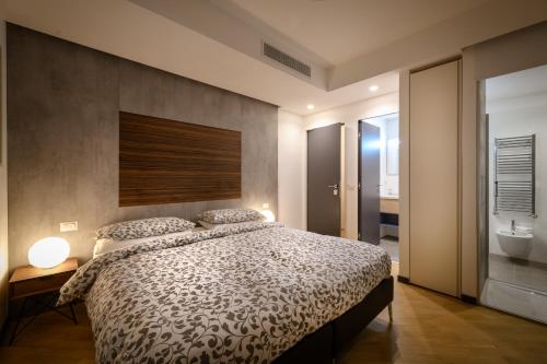 a bedroom with a large bed and a bathroom at Eco Rooms&Breakfast Tirano in Tirano