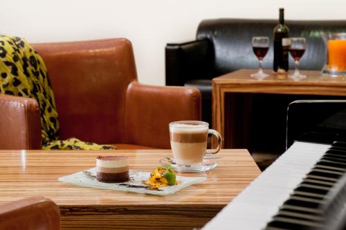a cup of coffee sitting on a table next to a keyboard at Leonardo Hotel Tiberias in Tiberias