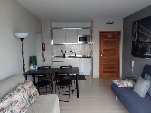 アルブフェイラにあるApartamento de Praia - Albufeiraのリビングルーム(ソファ、テーブル付)、キッチンが備わります。