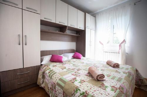 a bedroom with a bed with pink pillows on it at Apartment Green Oasis in Split