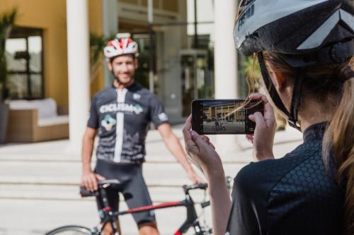a woman taking a picture of a man on a bike at Club del Sol Aparthotel in Port de Pollensa