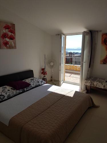 a bedroom with a large bed and a large window at Apartment Dijana in Kaštela