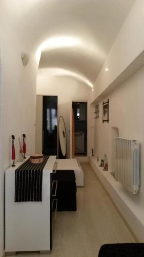 サンレモにあるElegante Loft Nel Cuore Di Sanremoのベッドと廊下が備わる広い白い客室です。