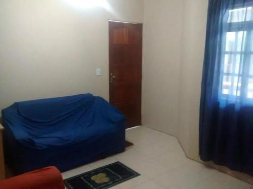 a room with a bed with a blue sheet on it at Apartamento de temporada in Rio das Ostras