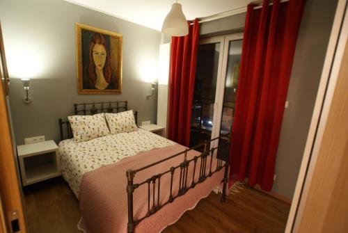 ビャウィストクにあるLeniwiecのベッドルーム(ベッド1台、赤いカーテン付)